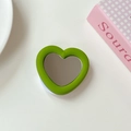 Macro shot of green heart-shaped phone grip with built-in mirror and expandable stand - Light Green