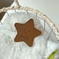 Close-up of brown star-shaped leather phone holder with Smile embossing and stitching - Coffee (Transparent Stand - Leather Pentagram)