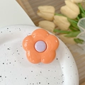 Vista macro di un supporto per cellulare a fiore arancione con finitura lucida su ceramica - Fiore Arancione