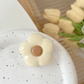 Detail of cream white flower phone grip stand with coffee brown center on artistic plate - Off-white Flower