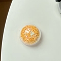 Makroansicht orangefarbener Herz-Pailletten im Rundgehäuse für DIY-Handyhalter - Gelb