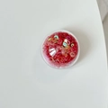 Macro shot of red round circle sequins in a clear container for DIY nail art and crafts - Colorful Sequins-Red