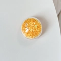 Macro view of transparent round case with orange DIY craft rings on light gray background - Colorful Sequins-Yellow
