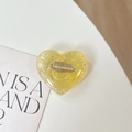 Détail macro du support de téléphone en cœur avec paillettes jaunes et logo - Support Coeur 3D - Feuille d'argent Anglais - Jaune