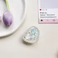 Detail of heart-shaped phone grip featuring a blue 3D bear star and pearls decor - Airbag Type Irregular Ring Tinfoil Texture Pearlescent Sea Star Bear / Blue