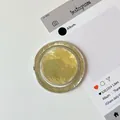 Λεπτομέρεια macro της στρογγυλής βάσης κινητού με υφή φύλλου χρυσού σε λευκό φόντο - Υφή Αλουμινόχαρτου Μαγνητική-Κίτρινο