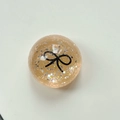 Dettaglio del supporto con paillettes champagne e motivo a fiocco nero minimalista - Supporto Sfera di Cristallo-Pois Glitter Fiocco Nero / Arancione