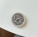 Vista macro dell'impugnatura per telefono con fiocco argento e bordi in strass - Supporto Trasparente - Fiocco / Grigio