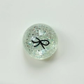 Macro shot of a transparent spherical phone grip bead with pink sequins and bow pattern - Crystal Ball Stand-Dots Glitter Black Bowtie / Light Green