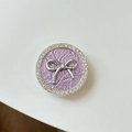 Detail of purple pleated phone grip featuring a silver bow and sparkling crystal border - Transparent Stand - Bowknot / Purple
