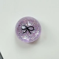Macro detail of purple glitter phone grip with a black bow pattern on a white base - Crystal Ball Stand-Dots Glitter Black Bowtie / Purple