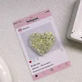 Gros plan d'un support de téléphone en forme de cœur avec paillettes dorées sur carte - Support Coeur Époxy Paillettes - Jaune Haute Brillance
