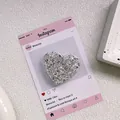 Gros plan d'un support de téléphone cœur avec paillettes argentées scintillantes sur décor - Support Coeur Époxy Paillettes - Argent Haute Brillance