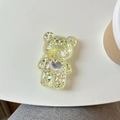 Supporto per telefono a forma di orso con paillettes dorate e cuore su tavolo bianco - Supporto per Airbag Orso / Giallo