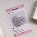 Détail du support de téléphone en forme de cœur avec paillettes violettes sur marbre - Support Coeur Époxy Paillettes - Violet Haute Brillance