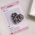Vue détaillée du support téléphone en cœur avec paillettes colorées sous résine - Support Coeur Époxy Paillettes - Noir et Blanc Multicolore