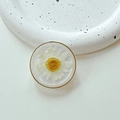 Vista macro del supporto per telefono in resina con margherita bianca vera e bordo oro - Bianco Nuvola Scintillante (Supporto Trasparente-Anello d'Oro Vero Fiore Margherita)