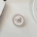 Dettaglio supporto cellulare con strass, fiocco argento e cristallo a cuore rosa - Bianco