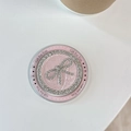 Dettaglio di un supporto per telefono in pelle rosa con fiocco di strass e scritta regalo - Rosa