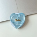 Macro view of blue glitter heart MagSafe phone stand with gold Smile lettering - Magnetic Large Crooked Heart Glitter Gold Smile / Blue