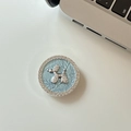 Macro view of blue leather phone socket featuring a rhinestone-studded silver balloon dog - Blue