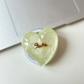 Detail of a green heart phone stand with glitter resin and a golden Smile emblem - Magnetic Large Crooked Heart Glitter Gold Smile / Light Green