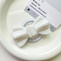 Macro detail of white glitter bow phone grip holder on elegant ceramic tray - Pearlized Large Bowknot-White