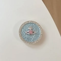 Detail of round rhinestone phone socket featuring pink gem saturn orb on blue background - Pink Rhinestone Planet - Blue