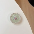 Detail of rhinestone round phone grip featuring silver planet orb design and pink gem - Pink Rhinestone Planet - Green