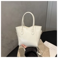Detalle de un bolso tote de cuero blanco con letras FASHION plateadas y correa fina - Blanco