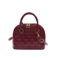 Glossy burgundy shell handbag with checkered texture and gold zippers on white background - Red