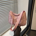 Pink underarm bag with 3D bow jacquard pattern and textured fabric held in hand - Pink