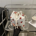 White canvas bucket bag with red strawberry print featuring a drawstring closure - Strawberry