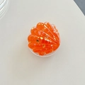 Detalle del soporte para móvil con forma de concha de resina naranja y pan de oro - Naranja