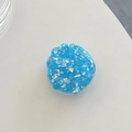 Macro detail of a blue shell-shaped resin phone grip with sparkling laser sequins - Blue