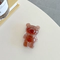 Macro shot of bear-shaped phone grip with gold foil inside transparent amber resin - Brown (Gold Foil Transparent Bear)