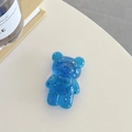 Detail eines blauen transparenten Bären-Handyhalters mit Goldfolie auf einem Tisch - Königsblau (Goldfolie Transparenter Bär)