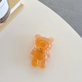 Detailaufnahme einer bernsteinfarbenen Handyhalterung in Bärenform mit Goldfolie - Orange (Goldfolie Transparenter Bär)