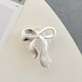 Detail view of a matte silver bow-shaped phone grip with Denise engraving on a desk - Transparent Epoxy Stand - Matte Bowknot - Silver