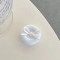 Macro shot of white matte circular phone grip featuring a minimalist decorative cream bow - White Bow Button