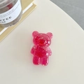 Detail shot of a clear pink bear phone grip with gold foil flakes on a desk - Rose Red (Gold Foil Transparent Bear)