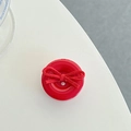Detail of red circular phone grip featuring a vibrant suede texture bow on smooth surface - Red Bow Button