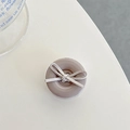 Detail of a grey button-shaped phone grip featuring a soft grey fabric bow accent - Khaki Bow Button