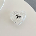 Macro shot of heart-shaped glitter phone grip with black bow pattern on acrylic - 3D Heart Polka Dot Glitter Black Bow / Clear