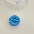 Close-up of blue button phone socket with a matte bow tie on white tabletop - Dark Blue Bow Button
