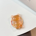 Vue détaillée du support de téléphone ours ambré avec feuille d'or et gravure - Orange