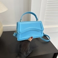 Detail of light blue structured handbag showing smooth faux leather and gold hardware - Light Blue