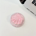 Detalle macro de un soporte de móvil de resina rosa con forma de concha y brillo vibrante - Estilo de Fragmento de Concha Magnética Brillante / Rosa