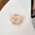 Dettaglio macro del supporto per telefono a fiocco rosa glitterato con testo inciso - Fiocco Grande Magnetico - Perlato / Arancione