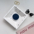Detail einer dunkelblauen, glänzenden Handy-Halterung auf einem weißen Display-Tablett - Marineblau